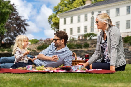 Familj på picknickfilt utanför Råda Säteri